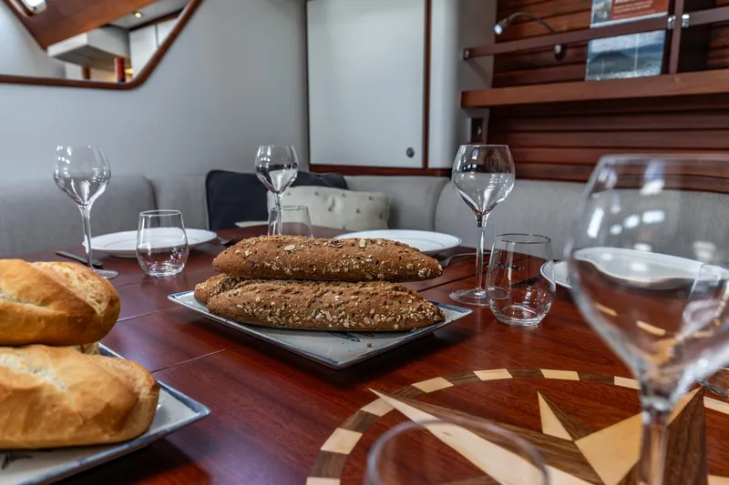 Red Rooster Yacht Photos Pics Dining area on 2008 Van De Stadt Stadtship 70 yacht with bread and glassware.