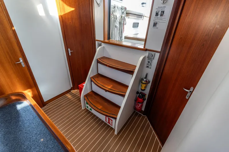 Red Rooster Yacht Photos Pics Interior of 2008 Van De Stadt Stadtship 70 yacht with wooden stairs and safety equipment.