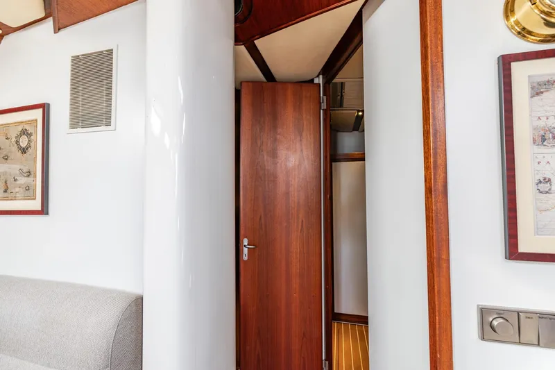 Red Rooster Yacht Photos Pics Interior of 2008 Van De Stadt Stadtship 70 yacht with wooden door and framed artwork.