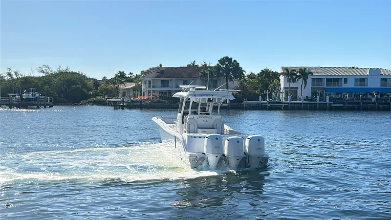 Seakeeper And Joystick Yacht Photos Pics 2020 Sea Fox 368 Commander boat cruising on a sunny waterfront with houses in the background.