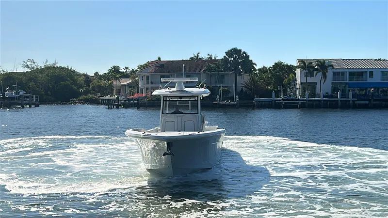 Seakeeper And Joystick Yacht Photos Pics 2020 Sea Fox 368 Commander boat cruising on a sunny waterfront with houses in the background.