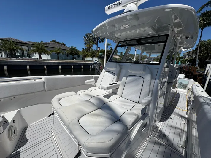 Seakeeper And Joystick Yacht Photos Pics 2020 Sea Fox 368 Commander boat with luxurious seating and modern design, docked by waterfront homes.