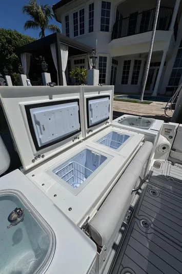 Seakeeper And Joystick Yacht Photos Pics 2020 Sea Fox 368 Commander boat with open storage compartments, docked near a luxury house.