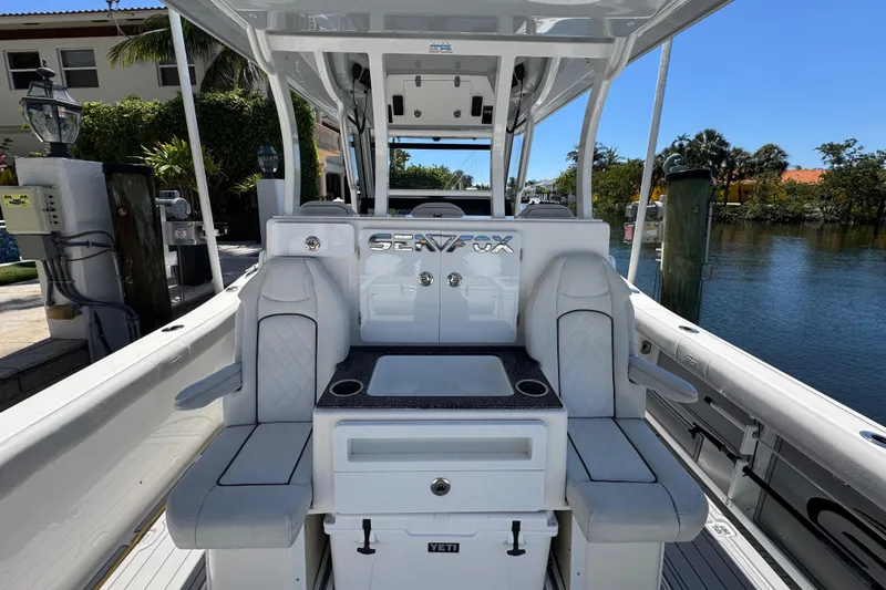 Seakeeper And Joystick Yacht Photos Pics 2020 Sea Fox 368 Commander boat interior with seating and console, docked by a waterfront.