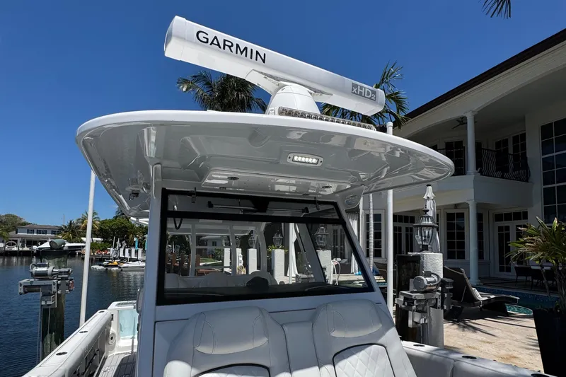 Seakeeper And Joystick Yacht Photos Pics 2020 Sea Fox 368 Commander boat with Garmin radar, docked near a waterfront home.