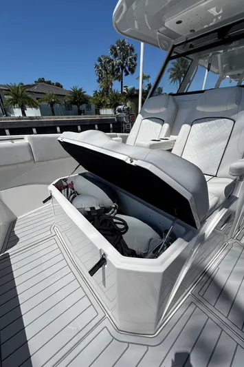 Seakeeper And Joystick Yacht Photos Pics 2020 Sea Fox 368 Commander boat with open storage compartment, docked near palm trees.