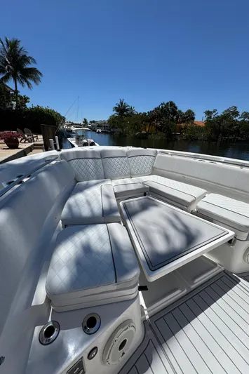 Seakeeper And Joystick Yacht Photos Pics 2020 Sea Fox 368 Commander boat with luxurious seating, docked by a scenic waterfront.