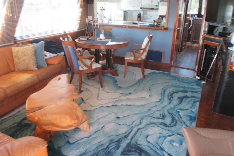 Hattitude Yacht Photos Pics Interior of 1981 Hatteras 61 Motor Yacht with elegant furnishings and blue patterned rug.