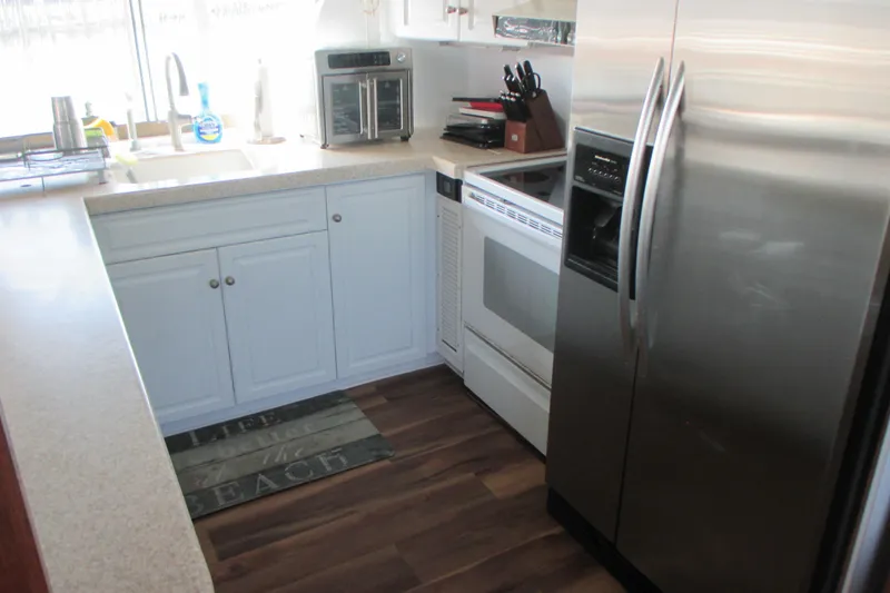 Hattitude Yacht Photos Pics Kitchen interior of 1981 Hatteras 61 Motor Yacht with modern appliances and wood flooring.