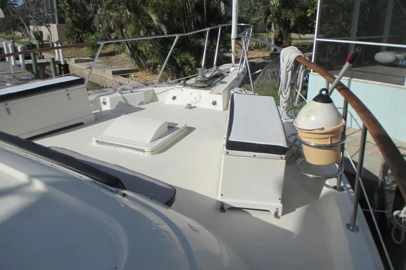 Hattitude Yacht Photos Pics 1981 Hatteras 61 Motor Yacht deck with seating and railing, docked near greenery.