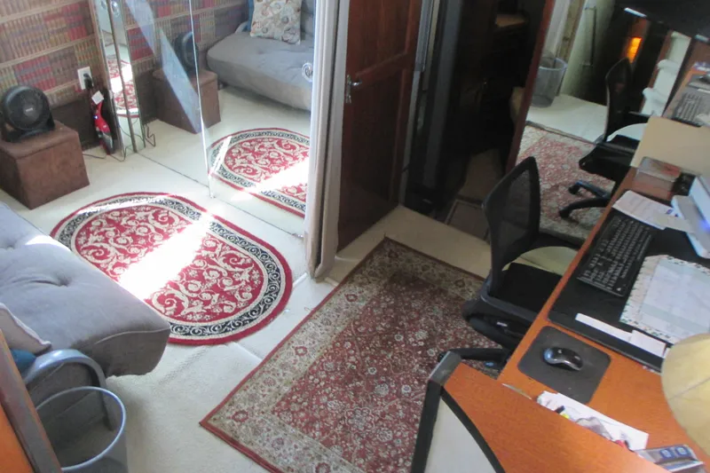 Hattitude Yacht Photos Pics Interior of 1981 Hatteras 61 Motor Yacht with rugs, desk, and seating area.