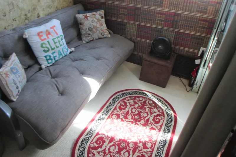 Hattitude Yacht Photos Pics Cozy interior of 1981 Hatteras 61 Motor Yacht with sofa, decorative pillows, and patterned rug.