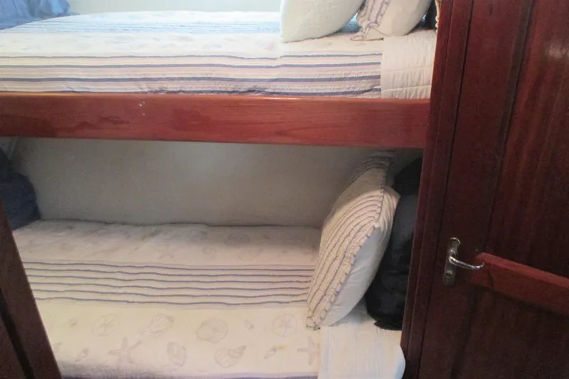 Hattitude Yacht Photos Pics Bunk beds in 1981 Hatteras 61 Motor Yacht cabin with striped bedding.