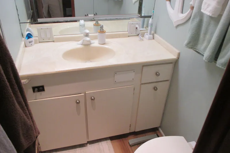 Hattitude Yacht Photos Pics 1981 Hatteras 61 Motor Yacht bathroom with sink, mirror, and toiletries.