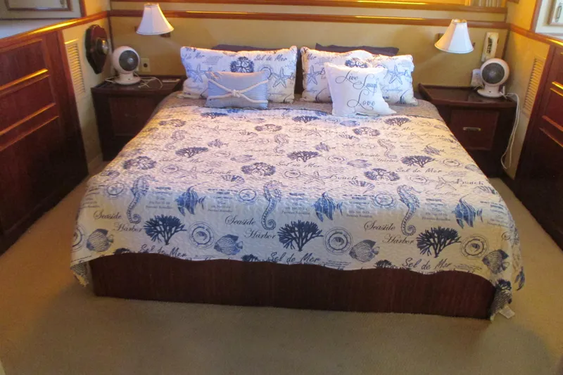 Hattitude Yacht Photos Pics Cozy bedroom in 1981 Hatteras 61 Motor Yacht with nautical-themed bedding.