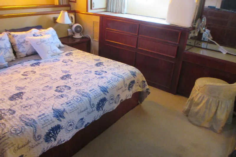 Hattitude Yacht Photos Pics Cozy bedroom interior on 1981 Hatteras 61 Motor Yacht with nautical-themed bedding.