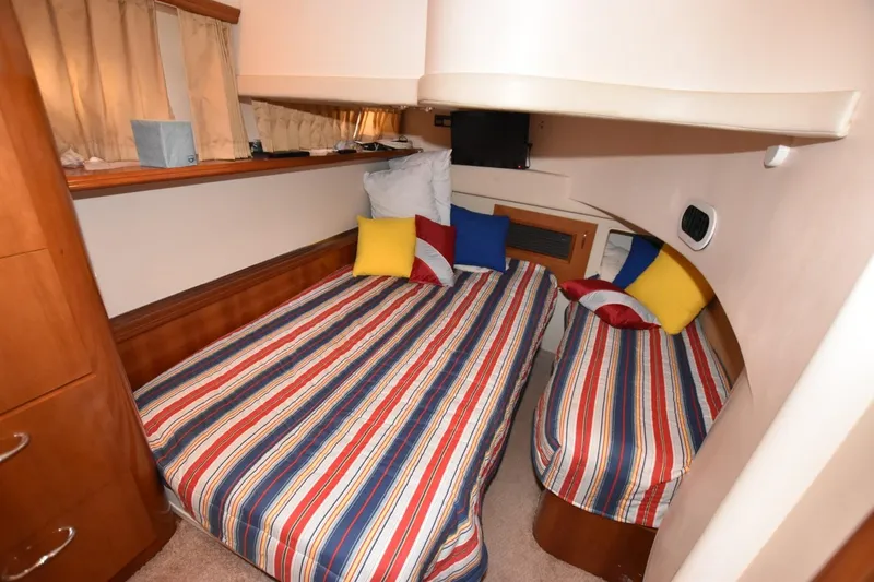 E2rt Yacht Photos Pics 2006 Carver 46 Voyager cabin with striped bedding and colorful pillows.