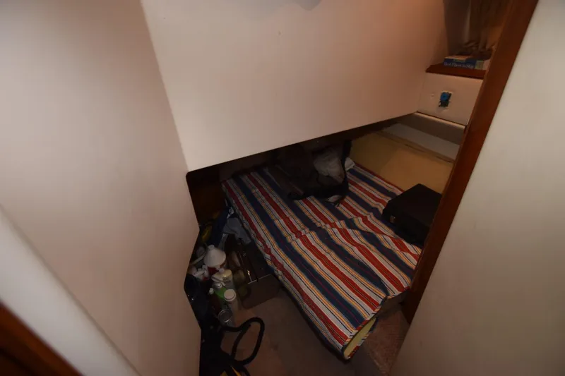 E2rt Yacht Photos Pics Small cabin interior of 2006 Carver 46 Voyager with striped bedding and storage items.