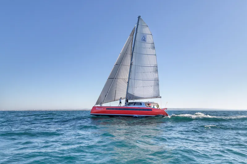 Ohana 8 Yacht Photos Pics Red Balance 526 sailboat gliding on open sea under clear blue sky, 2020 model.