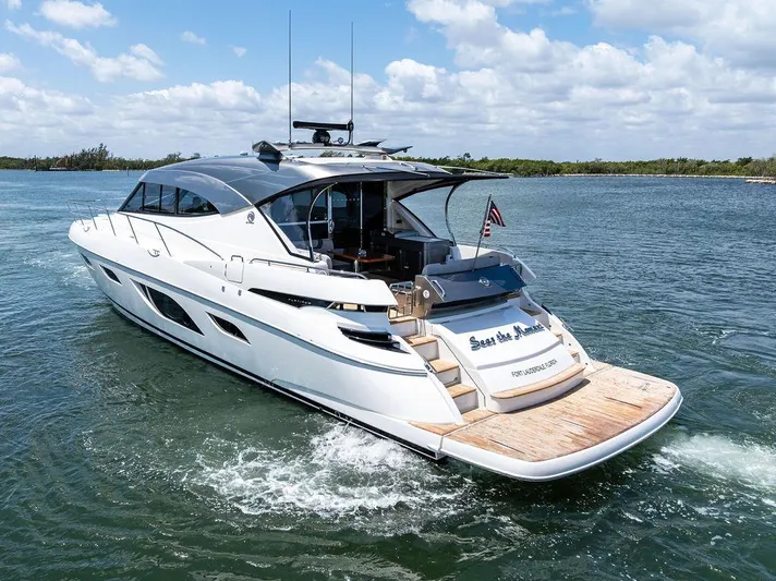 Seas The Moment Yacht Photos Pics 2022 Riviera 6000 Sport Yacht cruising on a sunny day, featuring sleek design and luxury amenities.