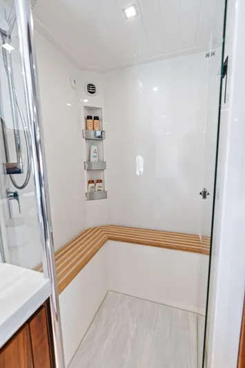 Seas The Moment Yacht Photos Pics Luxurious bathroom in 2022 Riviera 6000 Sport Yacht with wooden accents and modern fixtures.