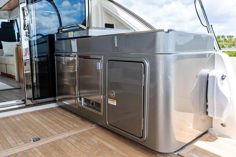 Seas The Moment Yacht Photos Pics 2022 Riviera 6000 Sport Yacht outdoor kitchen area with sleek cabinetry and modern design.