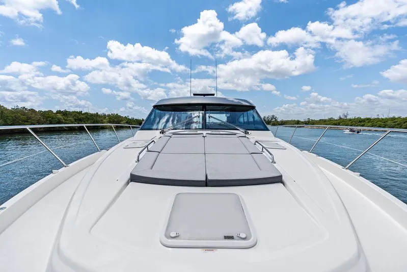 Seas The Moment Yacht Photos Pics 2022 Riviera 6000 Sport Yacht on water under blue sky with clouds.