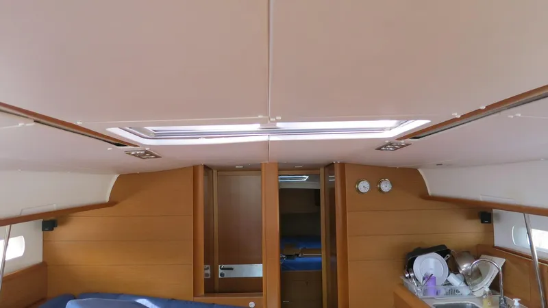 1305 Yacht Photos Pics Interior of 2013 Jeanneau Sun Odyssey 509 yacht, featuring wooden paneling and skylight.
