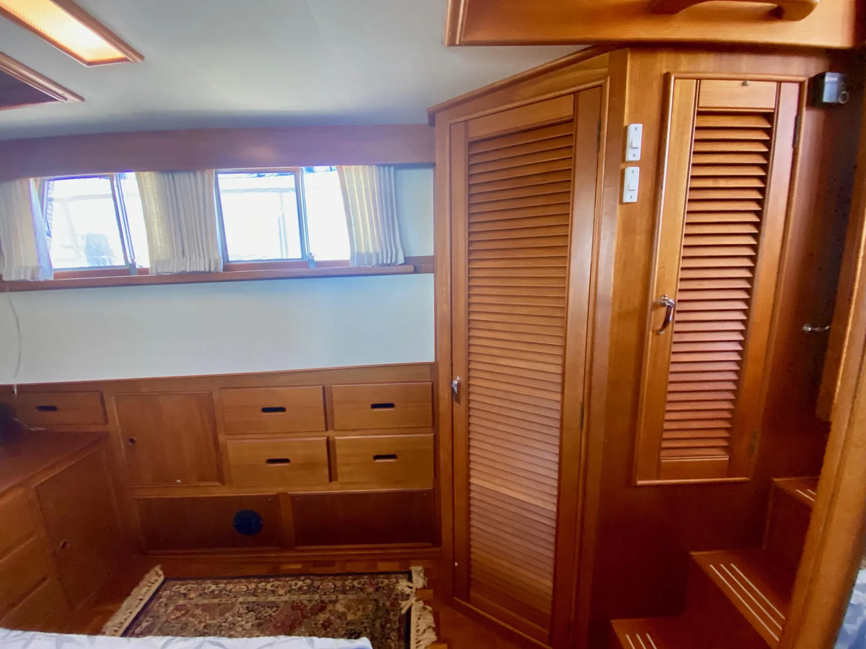 1997 Grand Banks Classic interior with wooden cabinetry and windows, showcasing elegant nautical design.