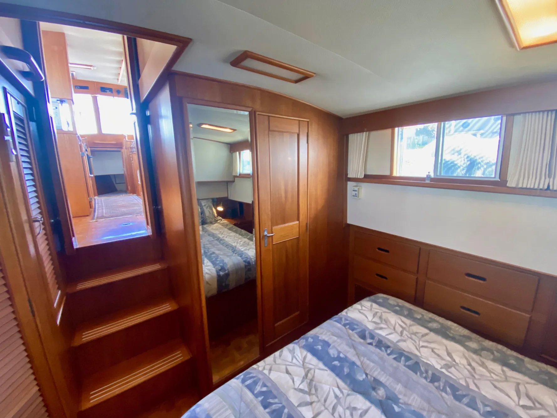 Cozy cabin interior of 1997 Grand Banks Classic yacht with wooden furnishings and bed.