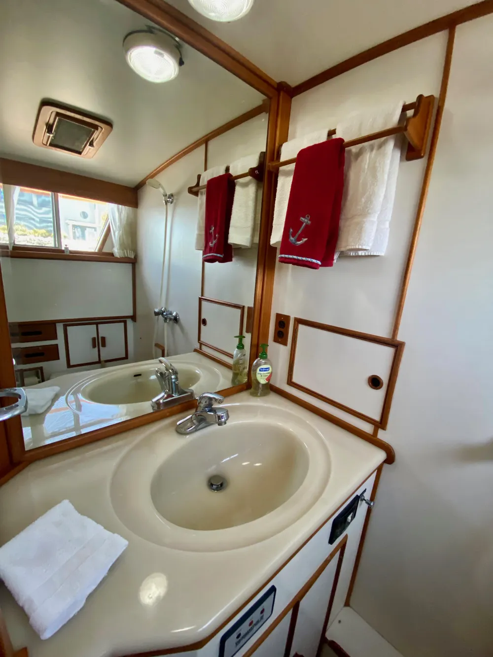 Bathroom interior of 1997 Grand Banks Classic yacht with sink and mirror.