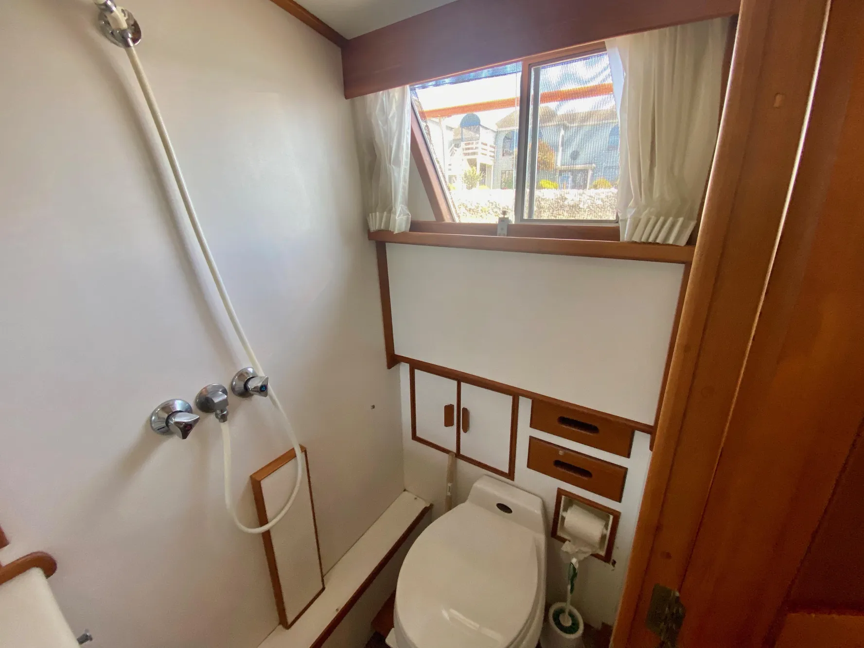 Bathroom interior of 1997 Grand Banks Classic yacht, featuring shower and toilet.