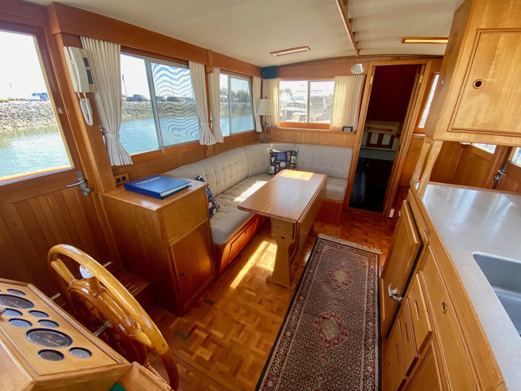Interior of a 1997 Grand Banks Classic yacht with wood finish and cozy seating area.