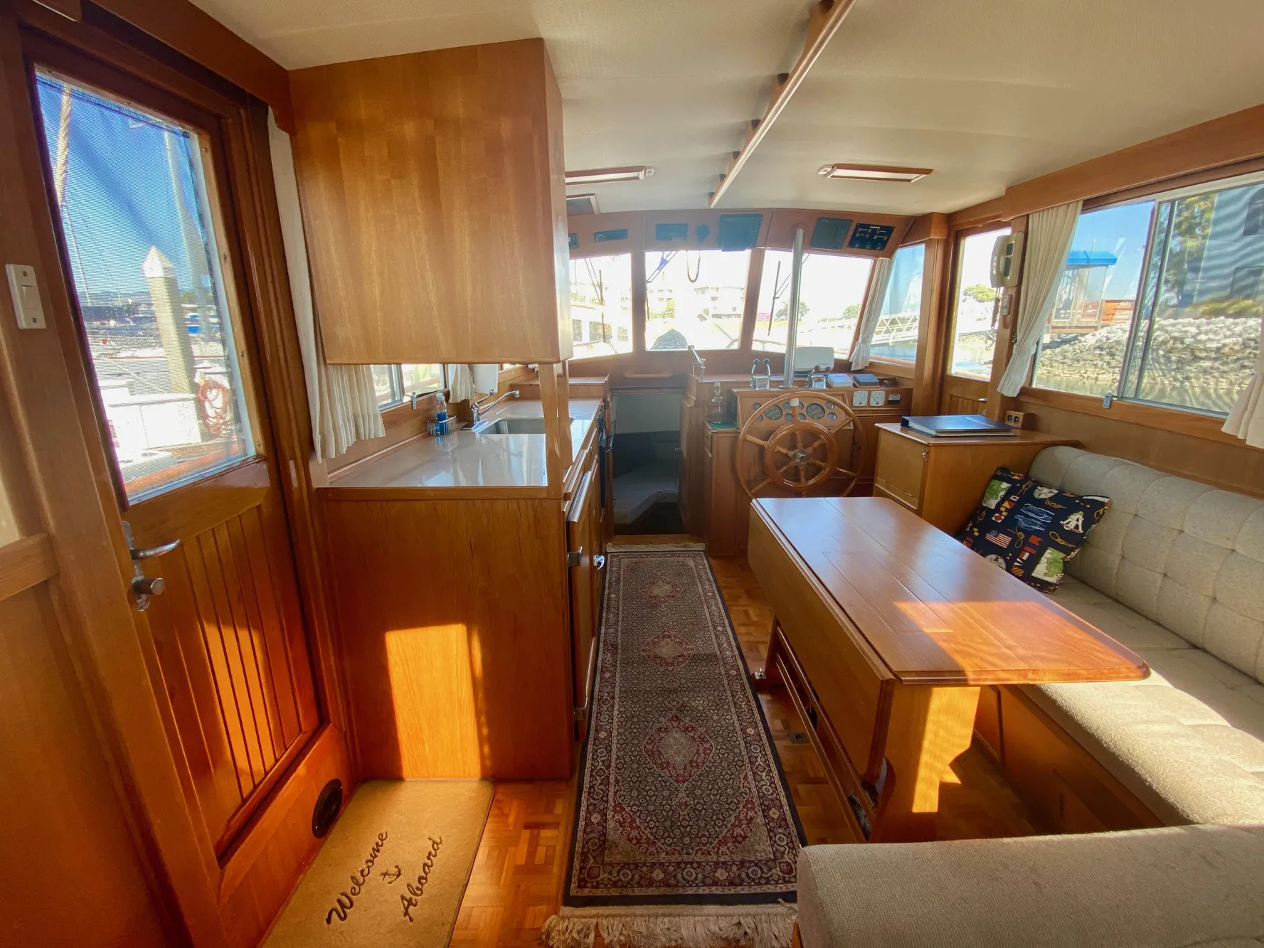 Interior of a 1997 Grand Banks Classic yacht with wooden furnishings and cozy seating.