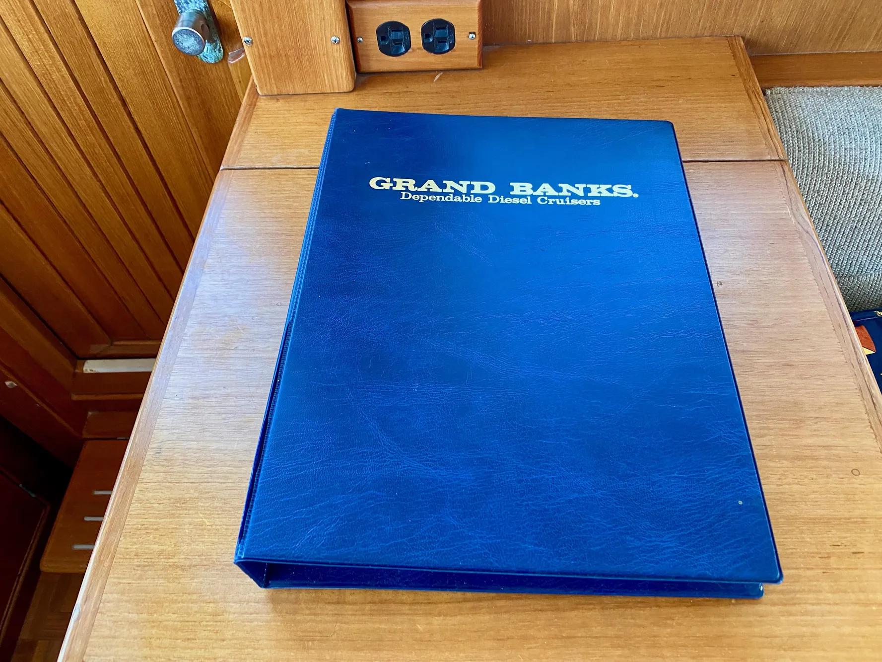 Blue Grand Banks manual on wooden surface, 1997 Classic model.