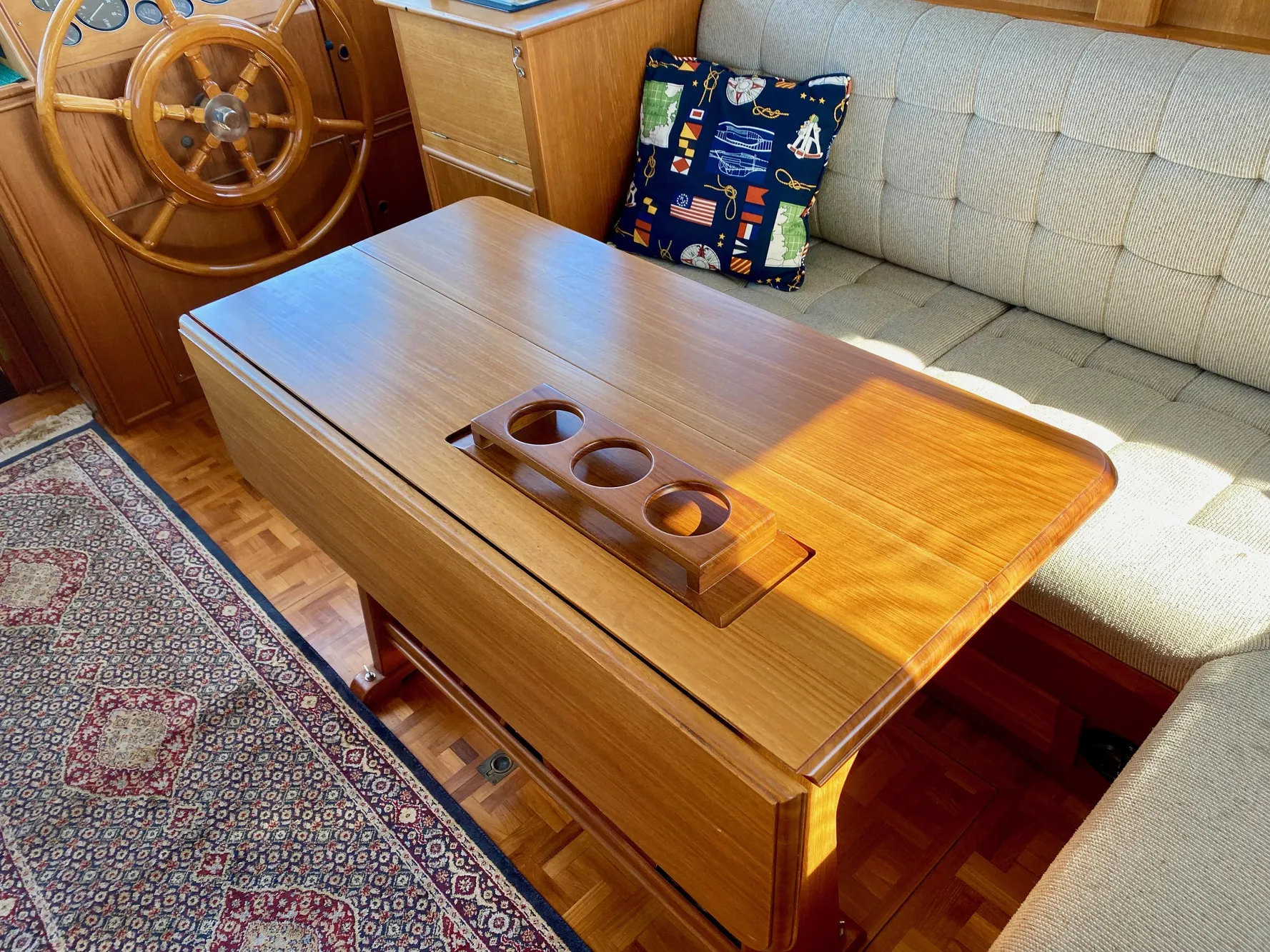 Cozy 1997 Grand Banks Classic interior with wooden table, nautical decor, and plush seating.