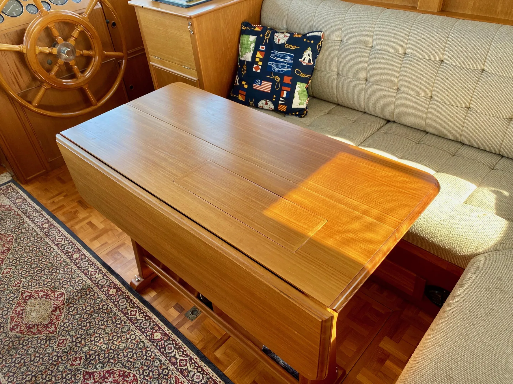 Interior of a 1997 Grand Banks Classic yacht with wooden table and cushioned seating.
