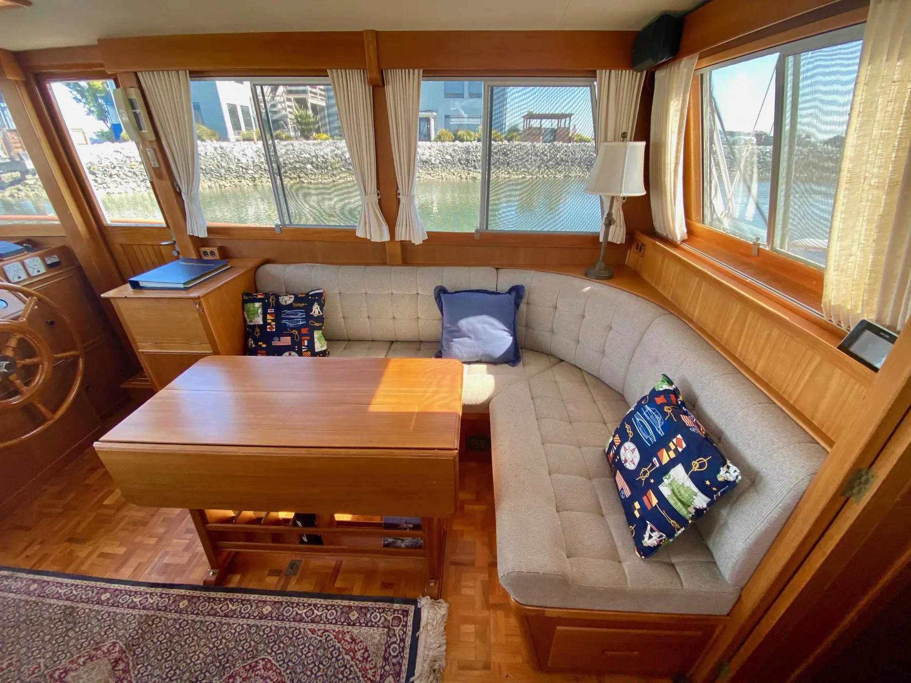 Interior of 1997 Grand Banks Classic yacht with cozy seating and wooden table.