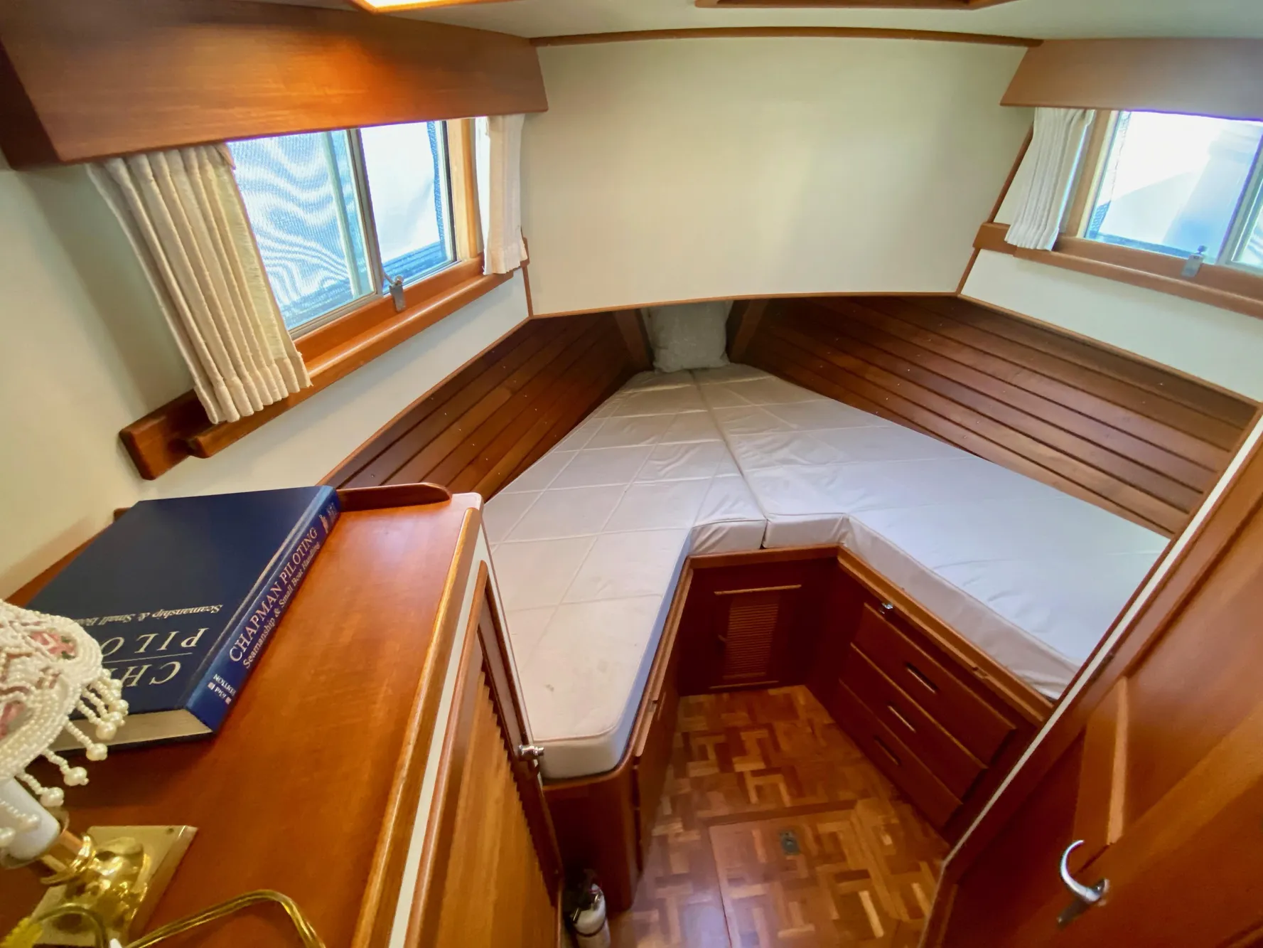 1997 Grand Banks Classic cabin with cozy bed, wooden interior, and nautical decor.