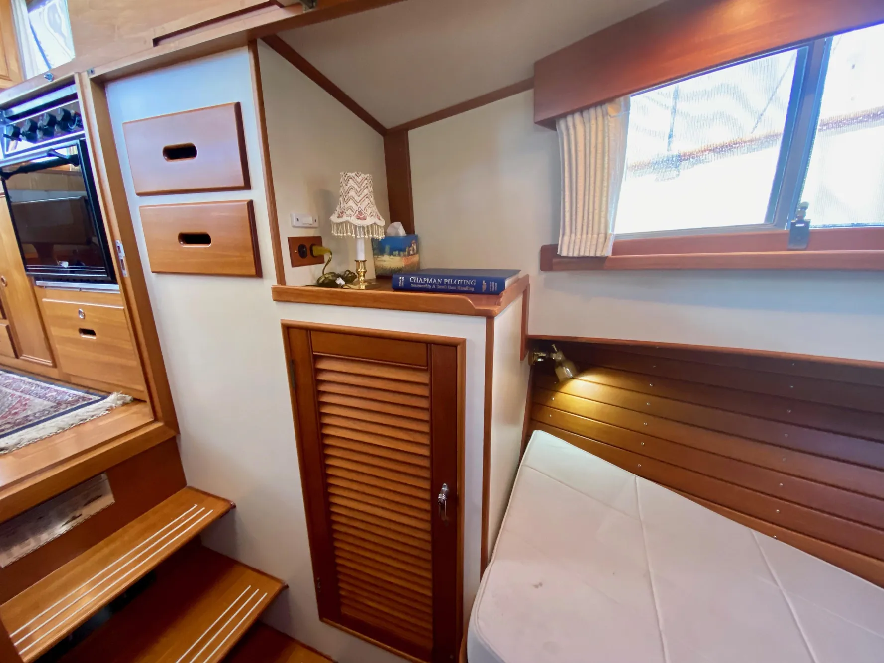 1997 Grand Banks Classic interior with wooden cabinetry, cozy seating, and nautical decor.