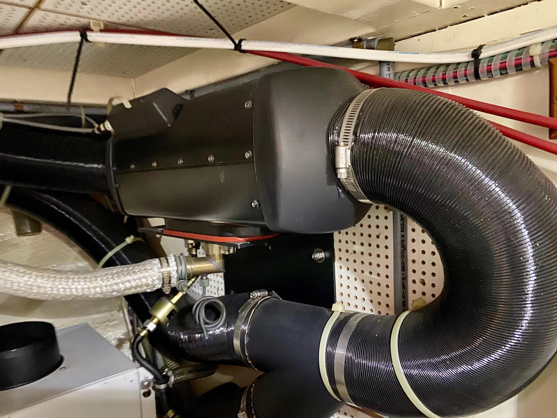 Engine room of a 1997 Grand Banks Classic boat with visible hoses and components.