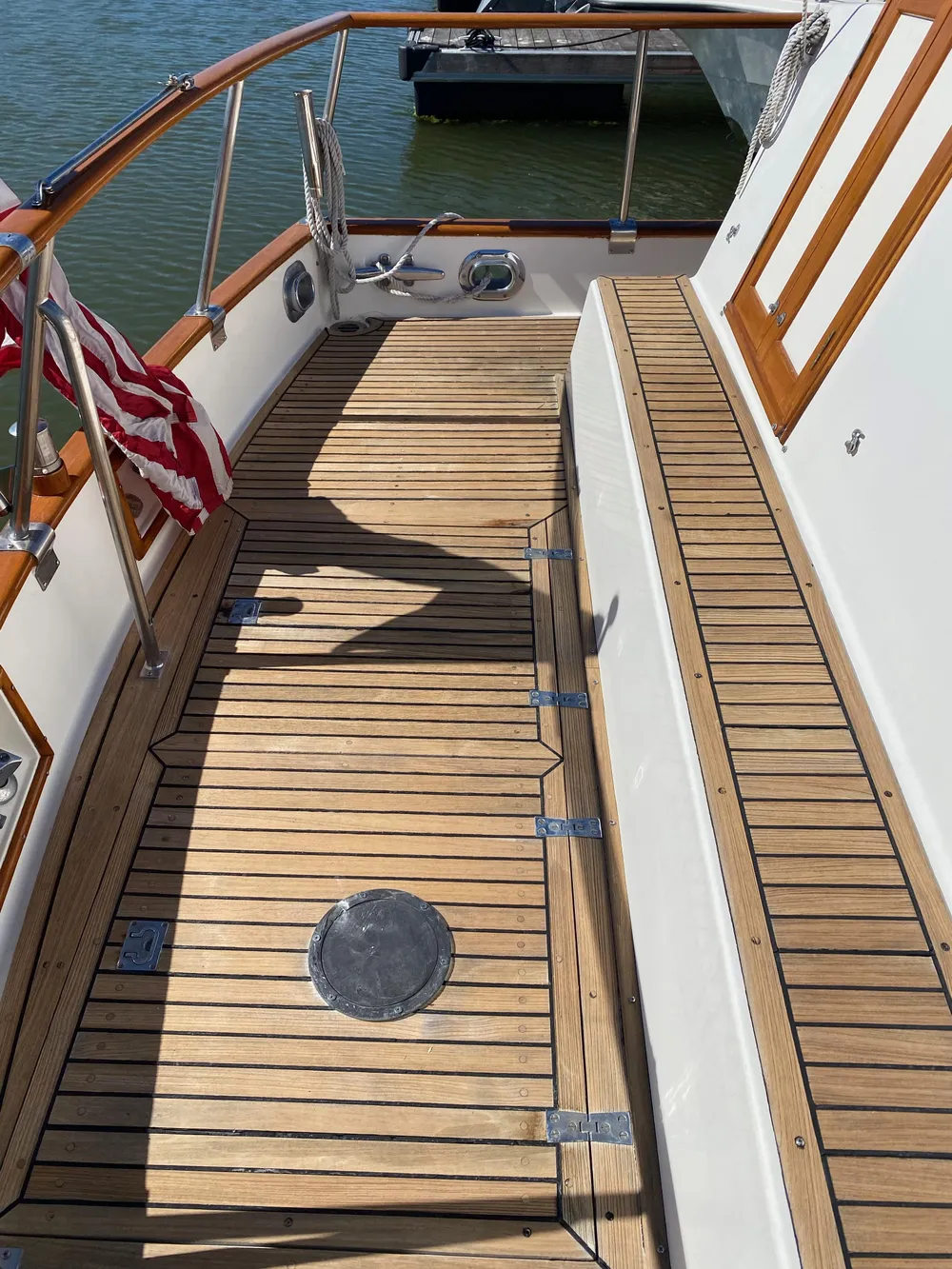 1997 Grand Banks Classic yacht with teak deck and American flag.