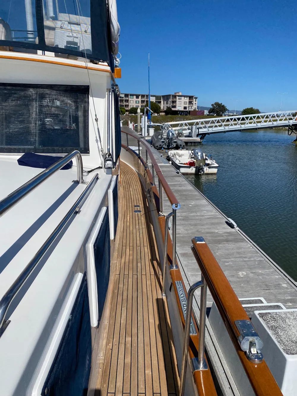 1997 Grand Banks Classic yacht docked at marina, showcasing wooden deck and sleek design.