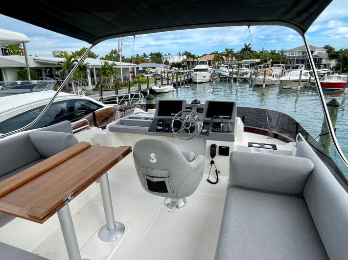  Yacht Photos Pics Flybridge of 2026 Beneteau Swift Trawler 41, featuring helm station and seating, docked in marina.