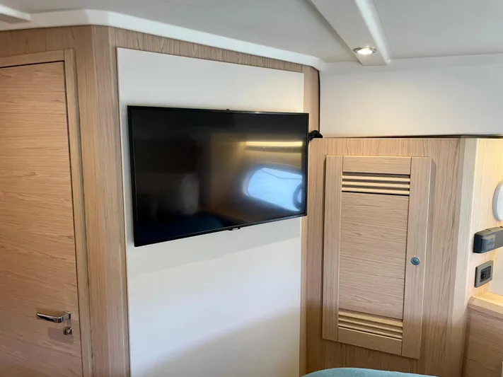  Yacht Photos Pics Interior of 2026 Beneteau Swift Trawler 41 with mounted TV and wooden cabinetry.