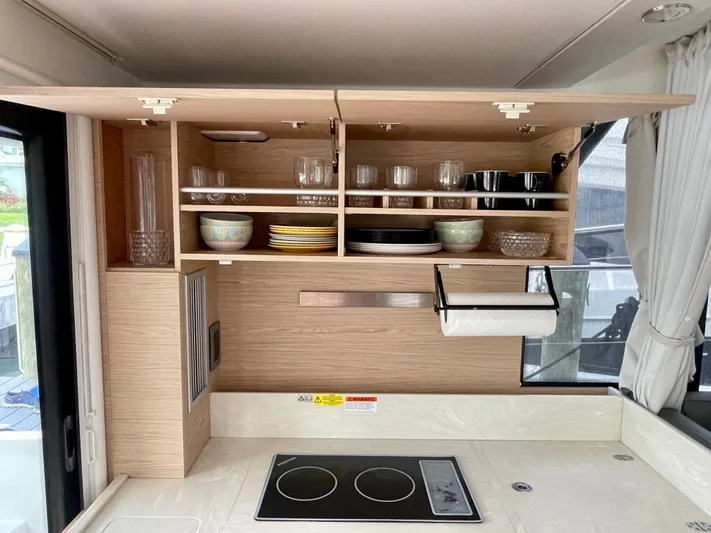  Yacht Photos Pics Modern kitchen interior of 2026 Beneteau Swift Trawler 41 with open cabinets and stovetop.