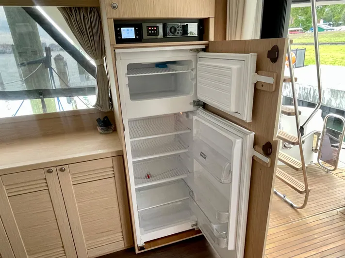  Yacht Photos Pics Open refrigerator inside 2026 Beneteau Swift Trawler 41, showcasing spacious interior and modern design.