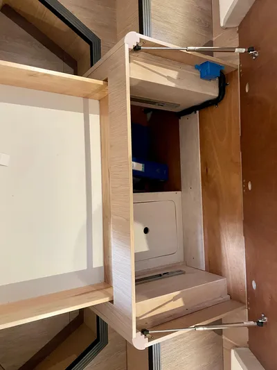  Yacht Photos Pics Interior view of 2026 Beneteau Swift Trawler 41, showcasing wooden cabinetry and storage space.