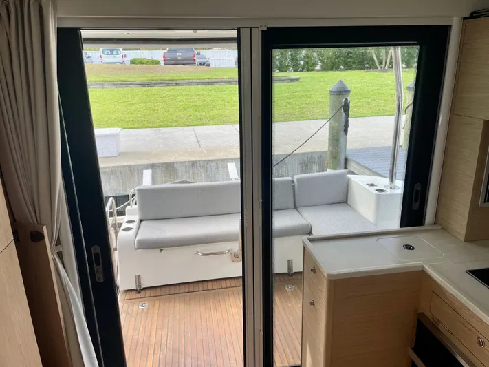  Yacht Photos Pics Interior view of 2026 Beneteau Swift Trawler 41, featuring sliding doors and outdoor seating.