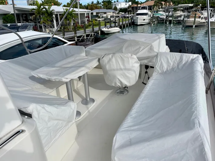  Yacht Photos Pics 2026 Beneteau Swift Trawler 41 deck with covered seating and table, docked at marina.